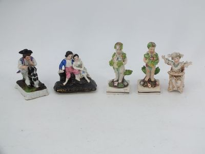 Plusieurs figurines représentant des personnes sont assises sur une surface blanche.