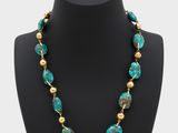 a necklace with turquoise and gold beads on a mannequin