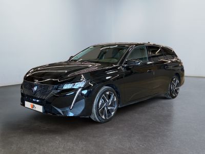 the black car is parked in a large room with a white wall