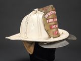 a white fireman ' s hat with patches on it