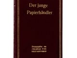 un livre rouge avec des lettres dorées posé sur une surface blanche