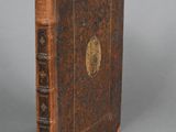 un vieux livre posé sur une table à côté d'un fond gris