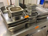 Plusieurs casseroles remplies d'aliments sont posées sur un plan de travail en inox.