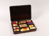 a wooden box with a variety of sewing supplies in it