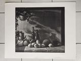 une photo en noir et blanc représentant une nature morte composée de fruits et d'une bouteille
