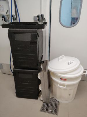 une poubelle à côté d'une autre poubelle, posées par terre
