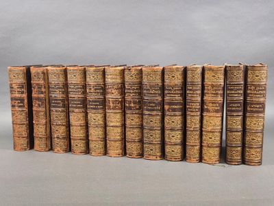 several old books are lined up in a row on a gray surface
