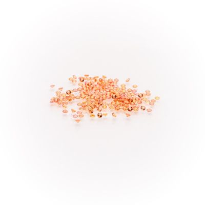 a pile of gold colored beads on a white background