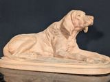 statue of a dog laying down on a marble surface