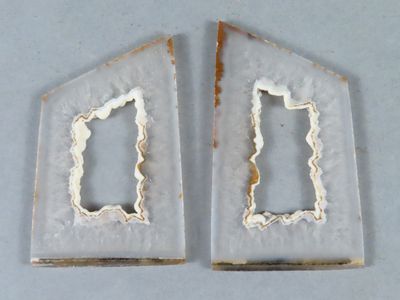 deux pièces de métal blanc et doré percées d'un trou au milieu
