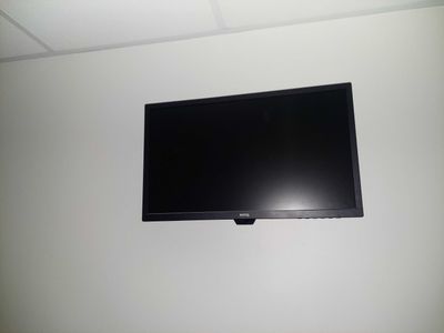 a flat screen tv mounted on the wall above a bed