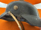 a person holding a helmet on a orange chair