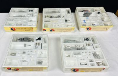Quatre boîtes contenant des objets divers sont posées sur une table.
