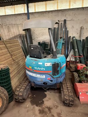 une petite pelleteuse bleue garée dans un garage