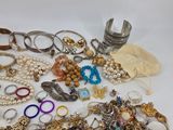 many different types of bracelets and rings on the table