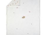 un gros plan sur une couverture blanche sur laquelle se trouve un ours en peluche