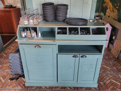 une armoire bleue sur laquelle sont posées de nombreuses bouteilles