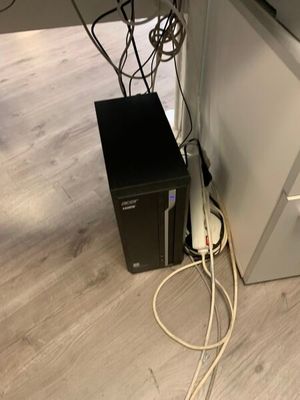 un ordinateur noir posé par terre à côté d'une armoire blanche