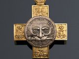 a gold cross with an image of a lion on it