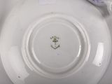 a white plate with a purple flower on it