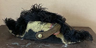 a black and gold hat with feathers on top of a table