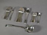 a lot of silver spoons and spoons on the table