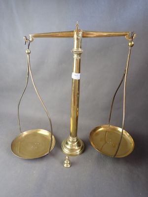 une vieille balance en laiton sur laquelle reposent deux plateaux vides