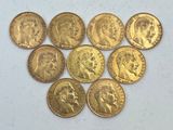 six types différents de pièces d'or sur une surface blanche