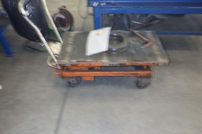 un chariot sur lequel repose un morceau de métal, dans un garage