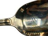 a silver spoon that is sitting on a white surface