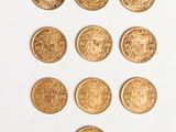 a close up of a bunch of gold coins on a white surface