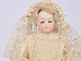 an antique doll of a woman in a wedding dress with a veil