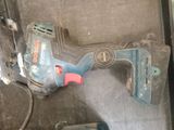 a drill that is laying on the floor next to a piece of paper