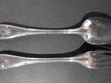 two spoons and a fork sitting on a table
