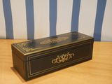a black and gold box sitting on a wooden table
