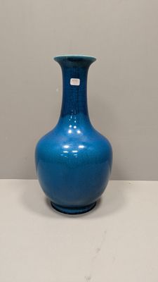 a blue vase that is sitting on a white table