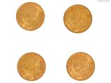 quatre pièces d'or sont disposées en ligne sur une surface blanche