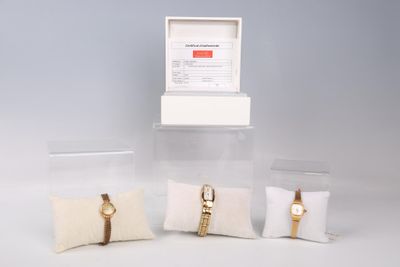 trois montres et un oreiller dans une vitrine