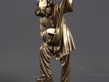 a bronze statue of a man playing a musical instrument on a rock