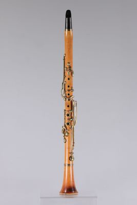 an orange and black clarinet on a clear surface