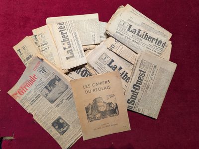 Plusieurs vieux journaux sont éparpillés sur une surface rouge