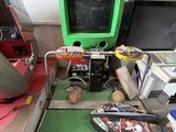 a green arcade machine sitting on top of a green mat