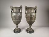 deux vases en argent posés l'un à côté de l'autre sur une table