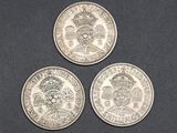 three british silver coins, one of which has a crown and the other of which is a sovereign