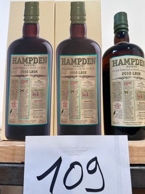 trois bouteilles de Hampden sont posées sur une étagère, avec une étiquette de prix