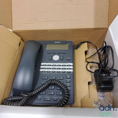 a box with a telephone and a charger inside of it