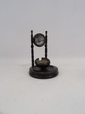 une horloge posée sur un socle, sur une surface blanche