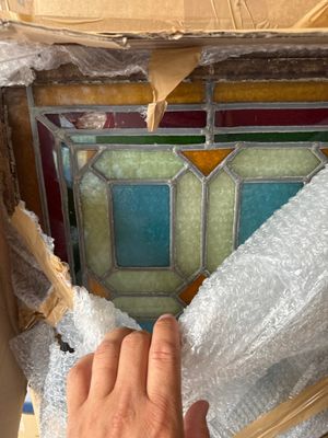 a man that is putting a piece of glass in a window