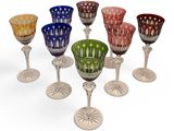 six different colored glass goblets sitting on top of each other