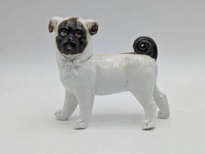 a small figurine of a pug dog on a white background
